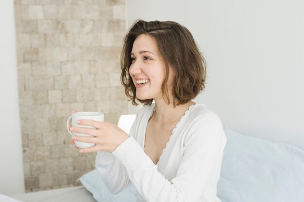 Femme avec une tasse de café à la maison