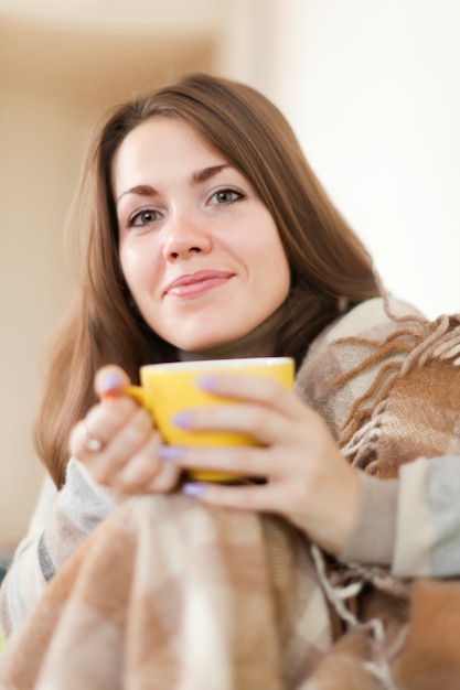 Photo gratuite femme avec tasse jaune à la maison