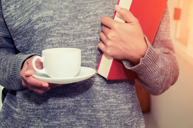 Femme avec une tasse et réserver