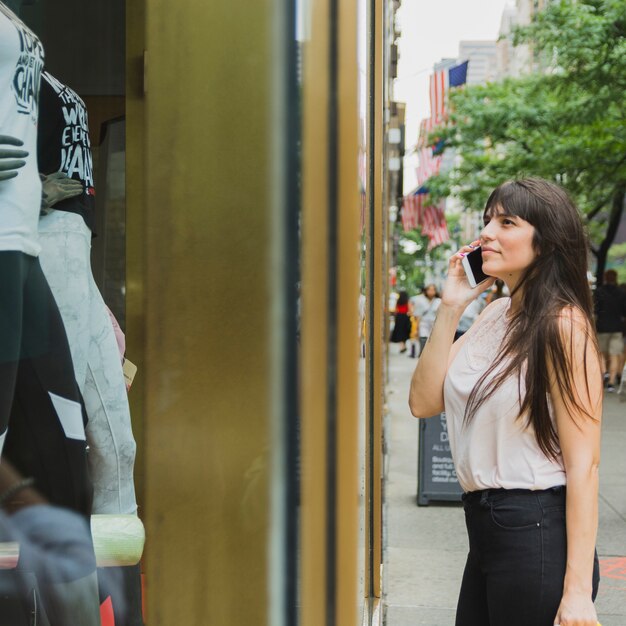 Femme téléphonant près d&#39;une vitrine