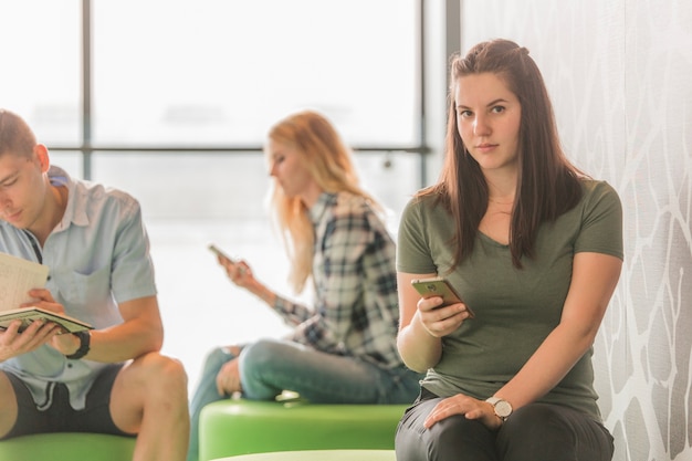 Photo gratuite femme avec le téléphone au collège