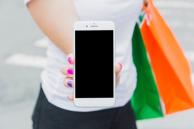 Femme avec téléphone et sacs à provisions