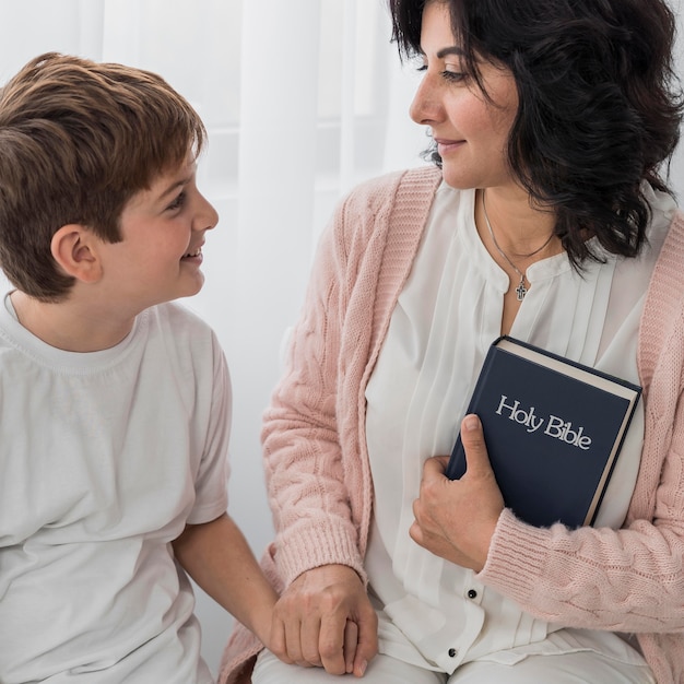 Photo gratuite femme tenant la bible avec son enfant