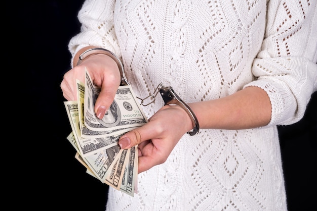 Femme tenant des billets d'un dollar dans des menottes