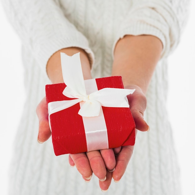 Femme tenant une boîte cadeau rouge dans les mains