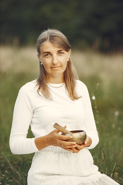 Photo gratuite femme tenant un bol chantant dans la nature