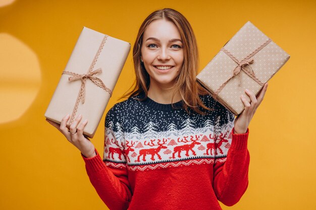 Femme tenant un cadeau de Noël sur jaune