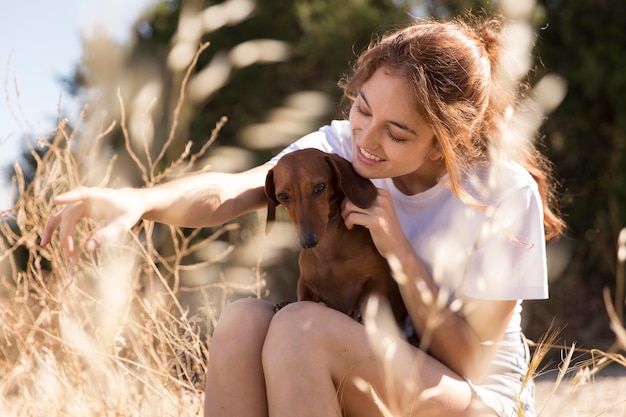 Femme tenant un chien mignon coup moyen