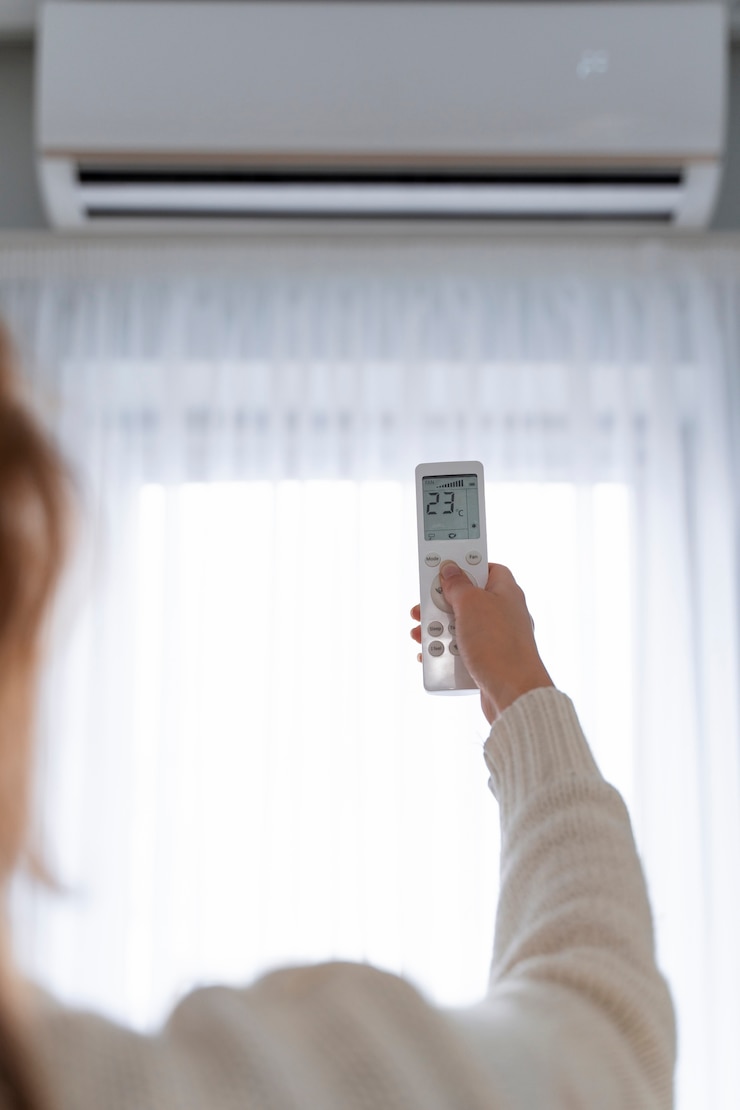 Photo gratuit femme tenant à distance pour démarrer le chauffage