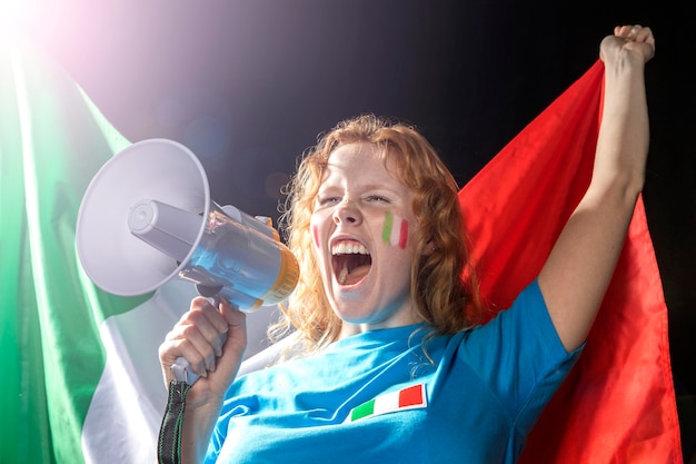 Femme tenant le drapeau italien et parlant au mégaphone