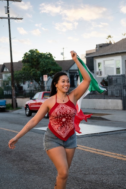 Femme tenant un drapeau mexicain dans la rue