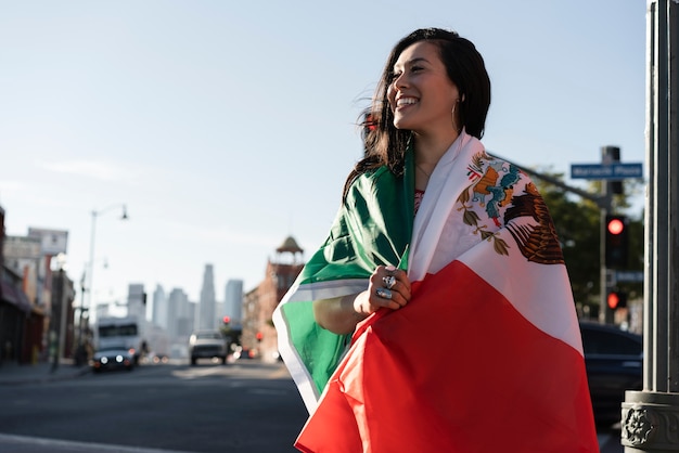 Femme tenant un drapeau mexicain dans la rue