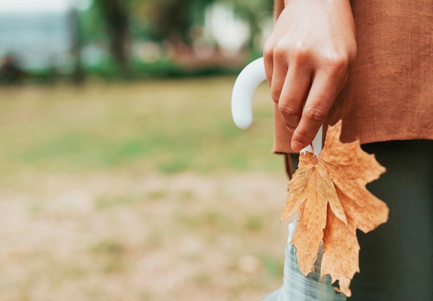 Photo gratuite femme tenant une feuille et un parapluie avec espace copie