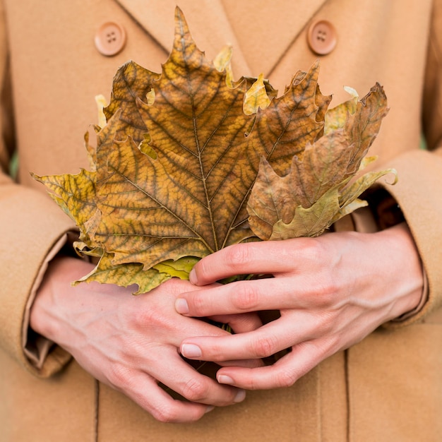 Femme tenant des feuilles d'automne