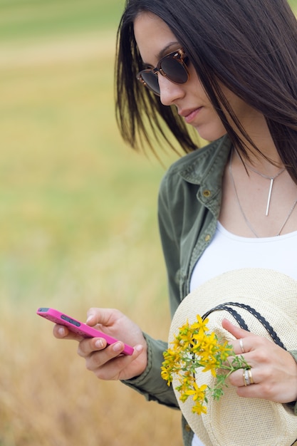 Photo gratuite femme tenant une fleur et téléphone navigation