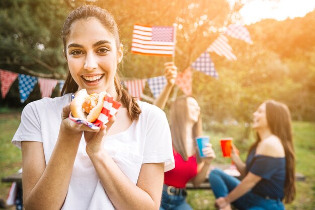 Femme tenant un hot-dog dans les mains