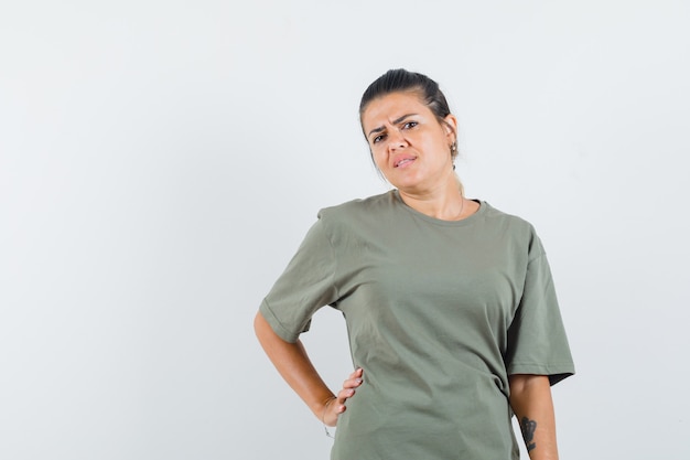 femme tenant la main sur la taille en t-shirt et à la sombre