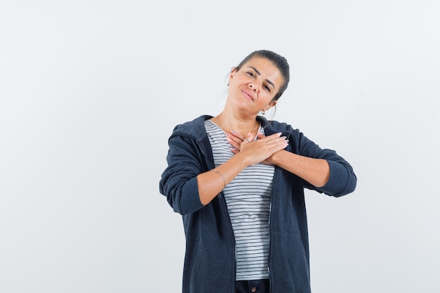 Femme tenant les mains sur le coeur en t-shirt