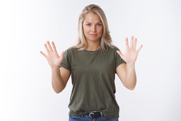 Photo gratuite femme tenant les mains comme toucher un mur invisible à la recherche d'un arrêt exigeant sérieux et sûr de soi