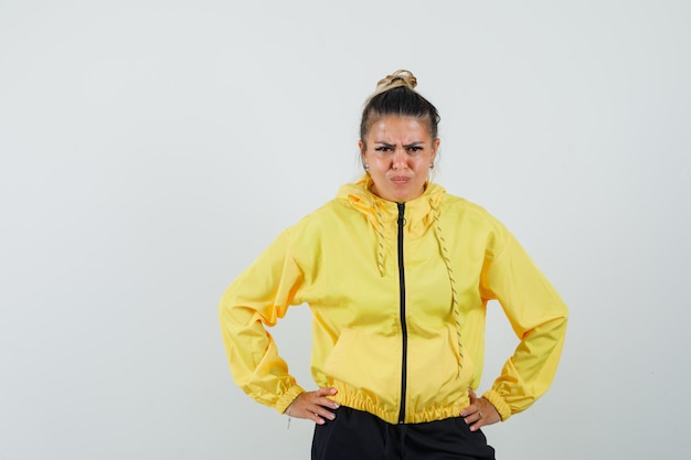 Femme tenant les mains sur la taille en costume de sport et à la méchante. vue de face.