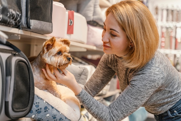 Femme tenant un mignon petit chien à l'animalerie