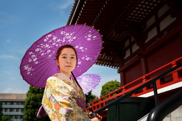 Femme tenant un parapluie wagasa à faible angle