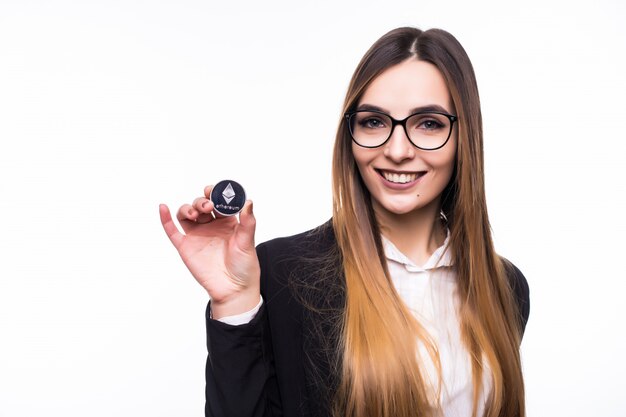 Femme tenant une pièce crypto-monnaie Ethereum physique dans sa main