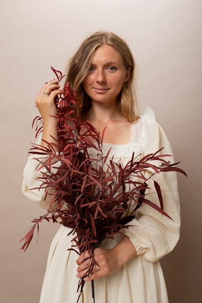 Femme tenant des plantes séchées vue de face