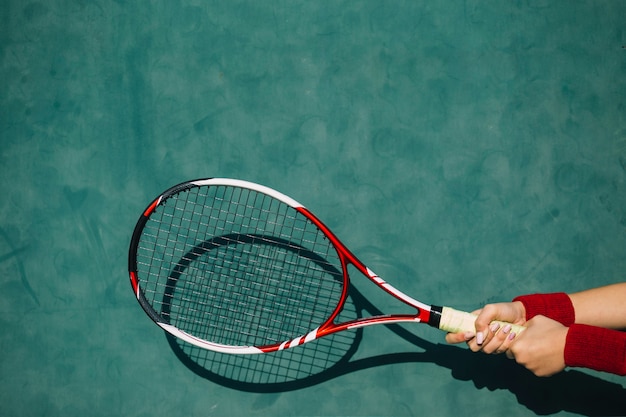 Femme tenant une raquette de tennis à deux mains