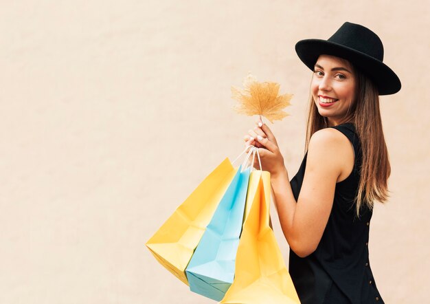 Femme tenant des sacs à provisions et une feuille avec espace copie