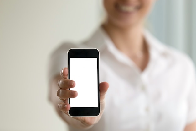 Femme tenant un smartphone, écran de maquette pour annonces mobiles, espace copie