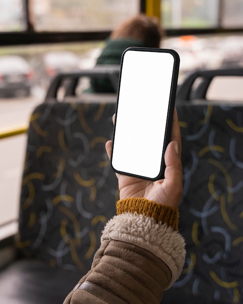 Femme tenant un smartphone vierge dans le bus