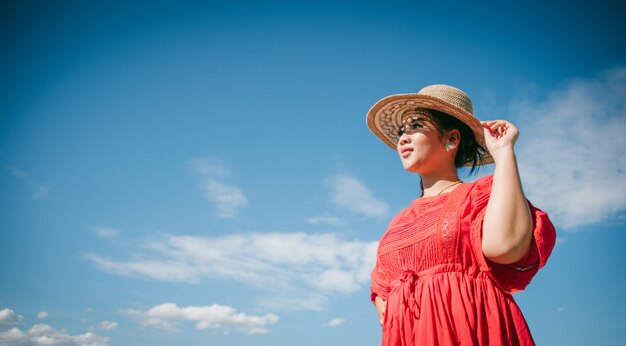 Femme tenant son chapeau