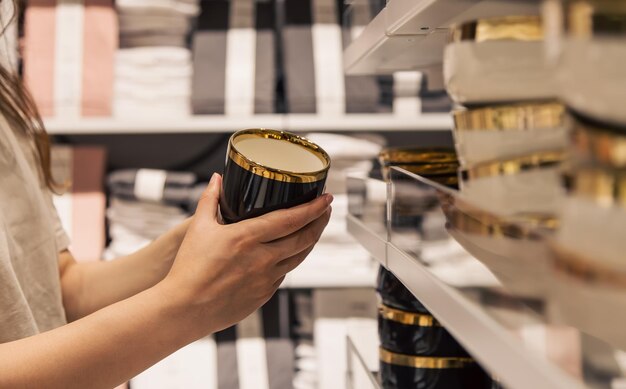 Femme tenant une tasse dans le magasin le concept de choisir des plats