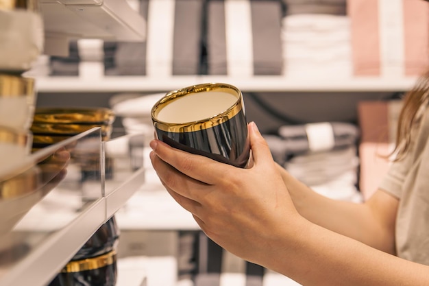 Femme tenant une tasse dans le magasin le concept de choisir des plats