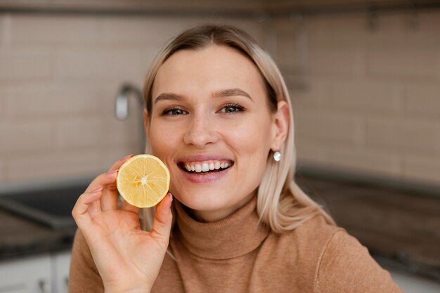 Femme tenant une tranche de citron se bouchent