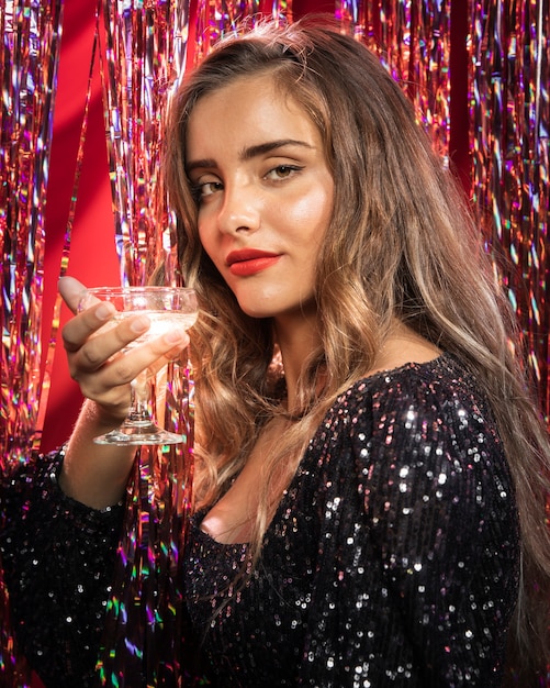 Photo gratuite femme tenant un verre de champagne sur le côté