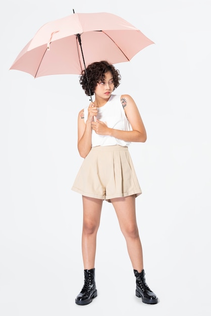 Femme tenant des vêtements décontractés parapluie rose