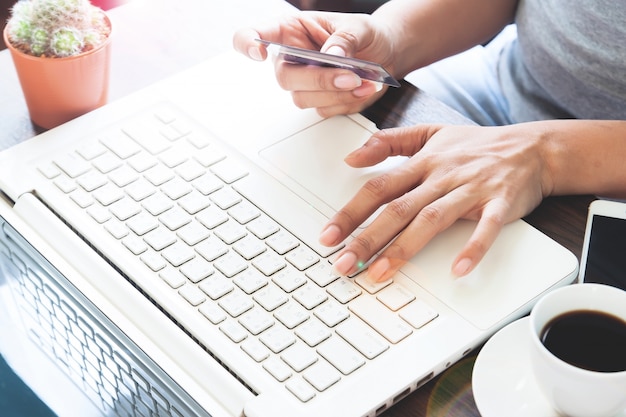 Femme en tenue décontracté avec ordinateur portable avec carte de crédit, Achat en ligne à la maison