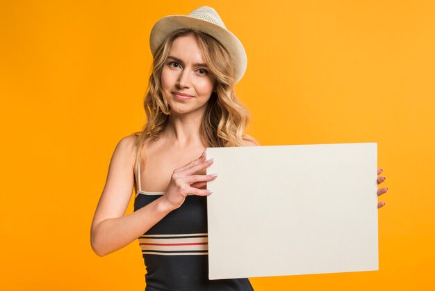 Femme en tenue d&#39;été tenant un papier vide