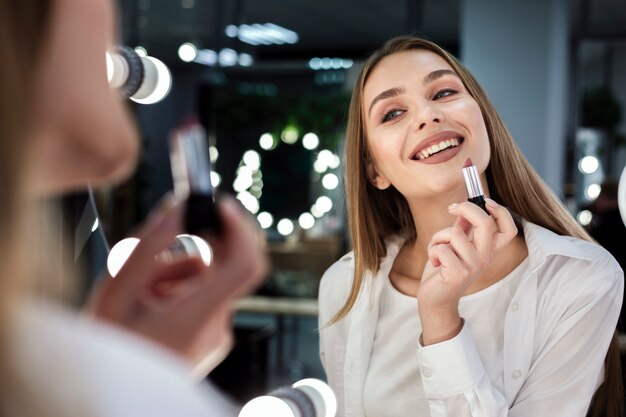 Femme, tenue, rouge lèvres, sourire, miroir