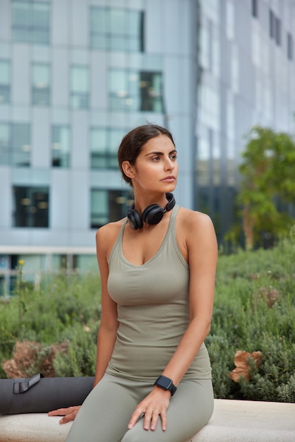 une femme en tenue de sport concentrée de côté prend une pause pensive après des exercices d'aérobic