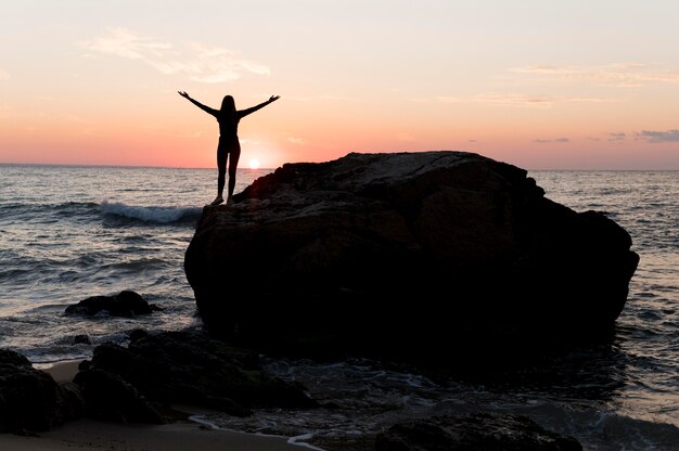 Femme en tenue de sport profitant du coucher du soleil avec espace copie