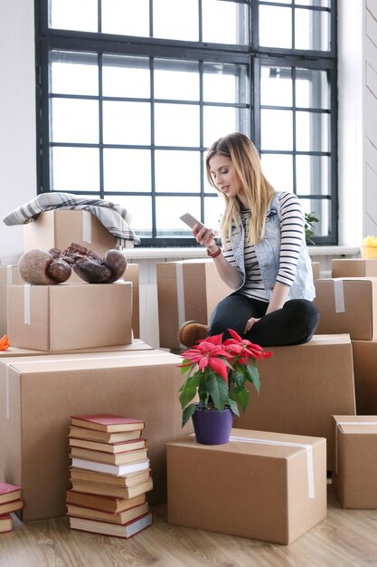 Une femme a terminé avec des colis et appelle un courrier pour l'expédition