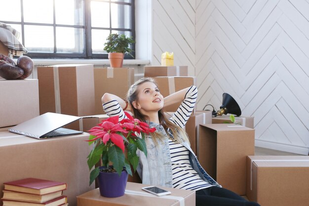 Femme a terminé avec des colis et est assise par terre de manière satisfaite