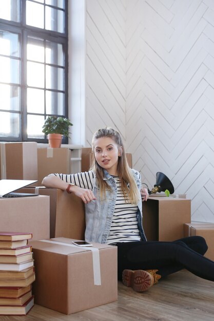 Femme a terminé avec des colis et est assise par terre de manière satisfaite