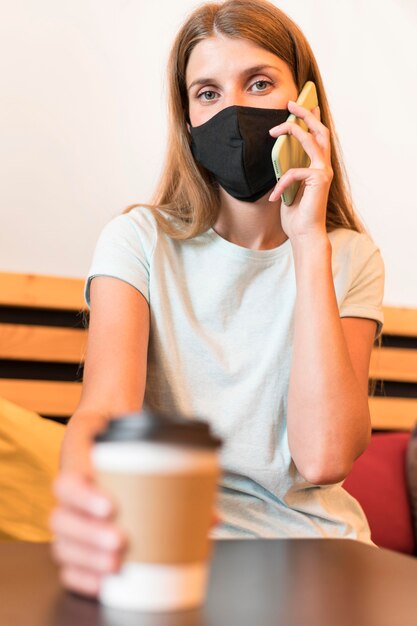 Femme à la terrasse avec masque