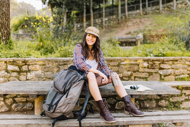 Femme avec thermos sur la table