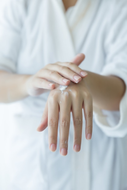 Photo gratuite femme tient un pot avec une crème cosmétique dans ses mains