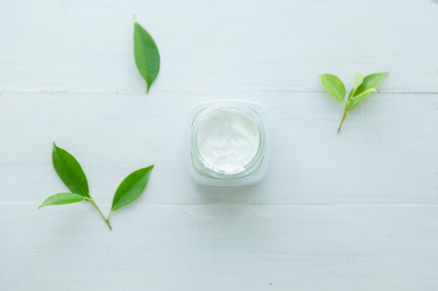 femme tient un pot avec une crème cosmétique dans ses mains